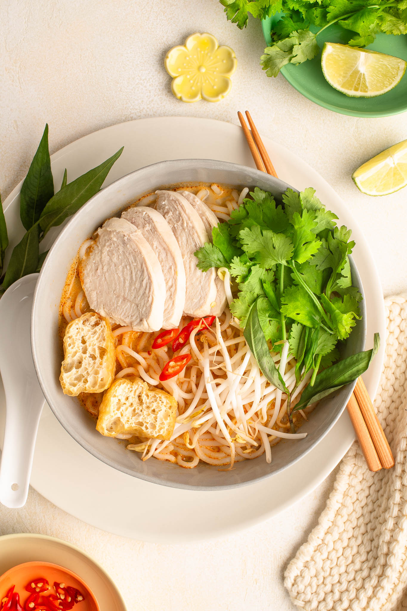 chicken laksa with fresh herbs in bowl