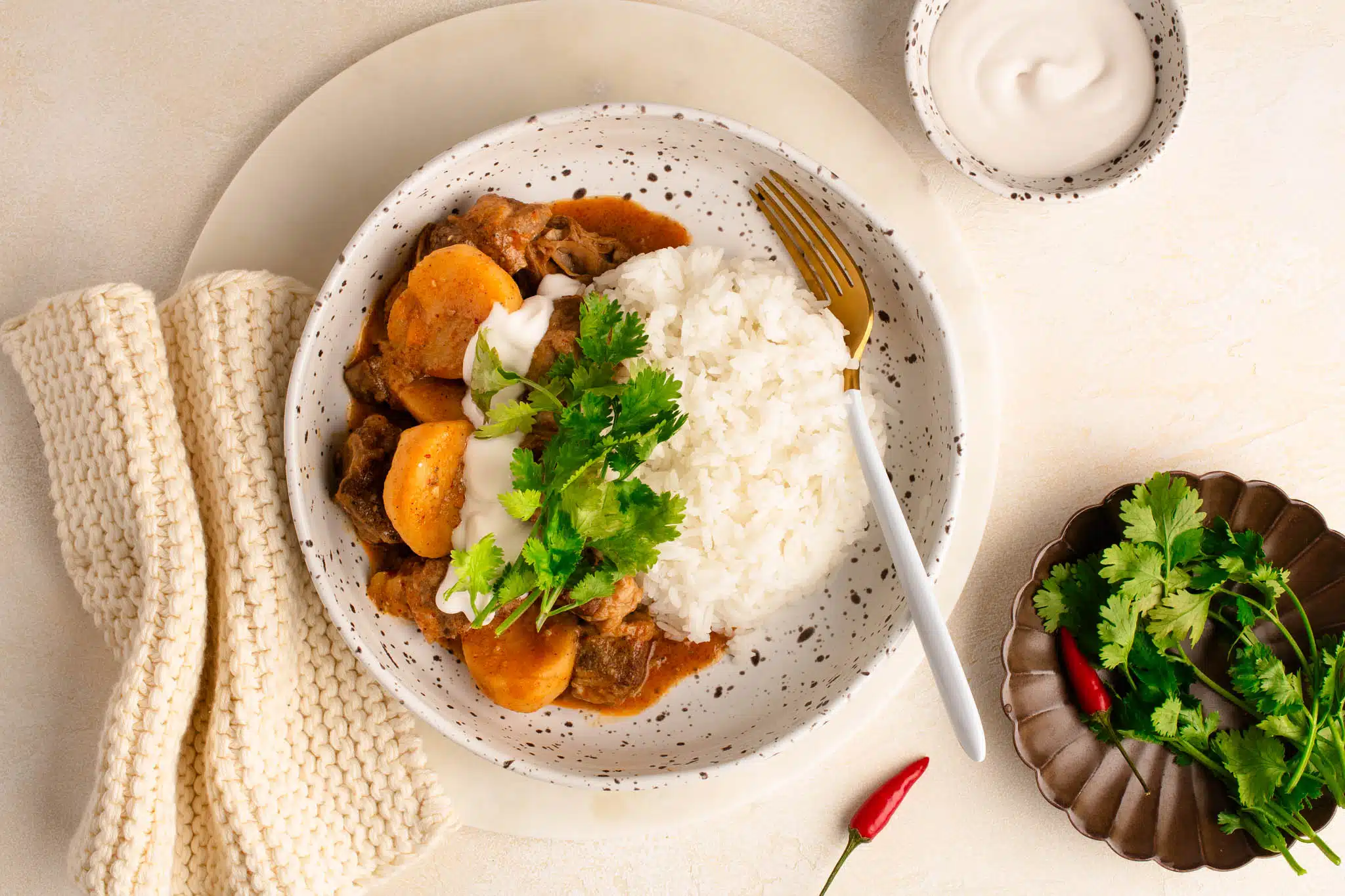 beef massaman curry with rice and garnished with coriander in bowl
