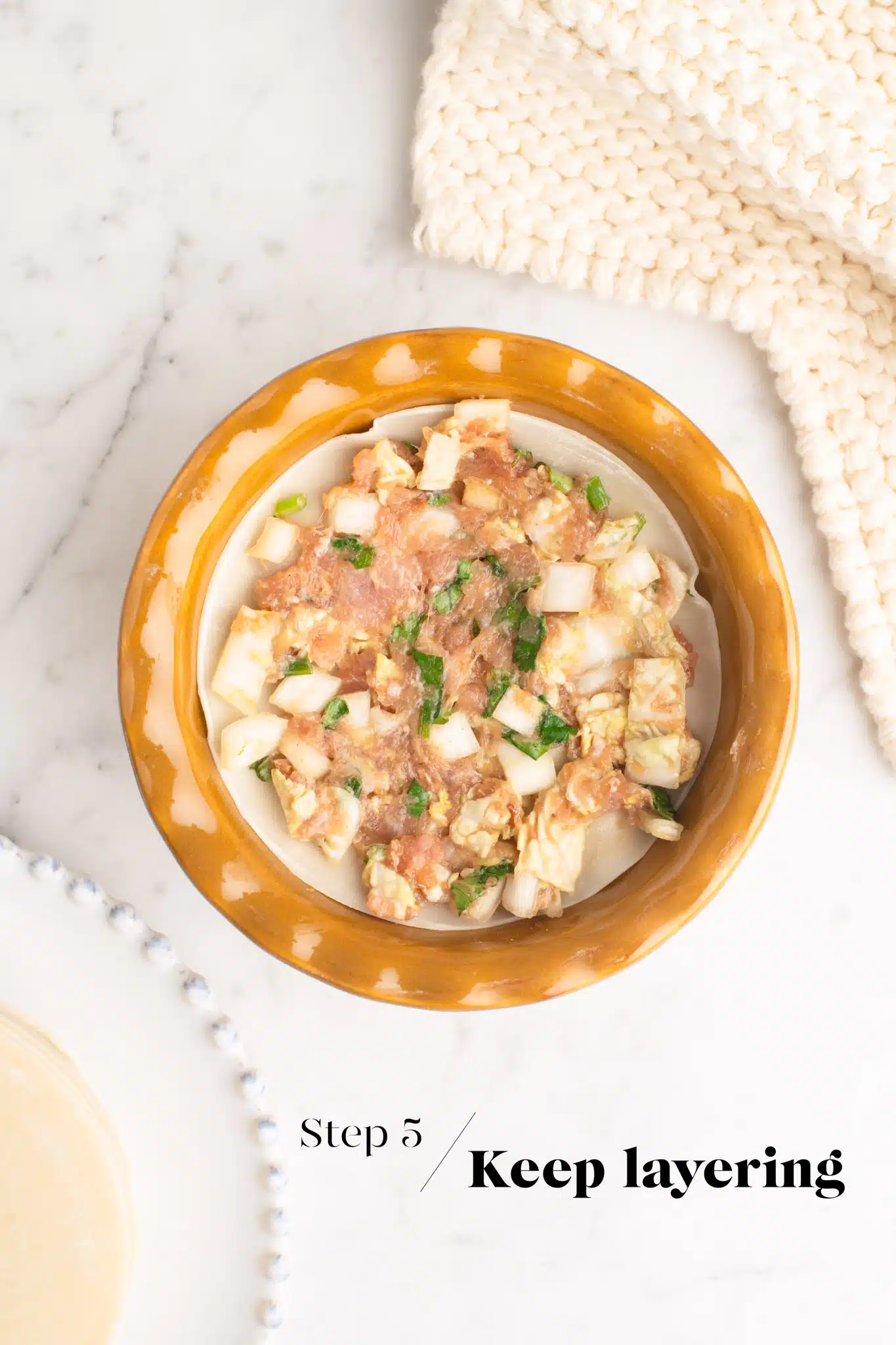 layers of dumpling lasagna in ceramic pie dish