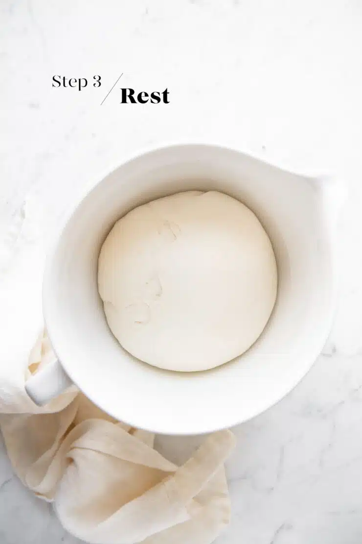 resting the bao bun dough in white mixing bowl