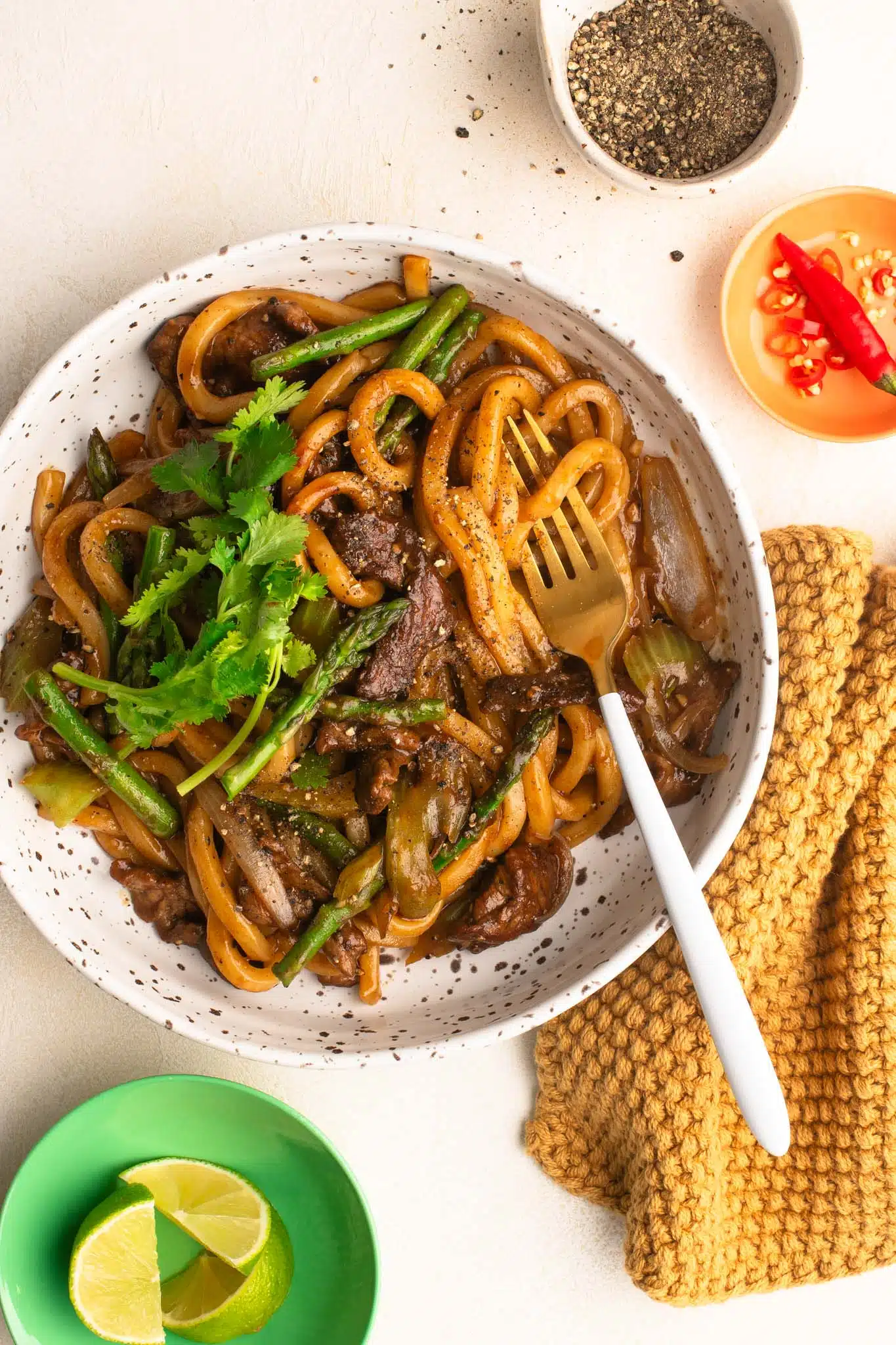 black pepper beef noodles in bowl with fork