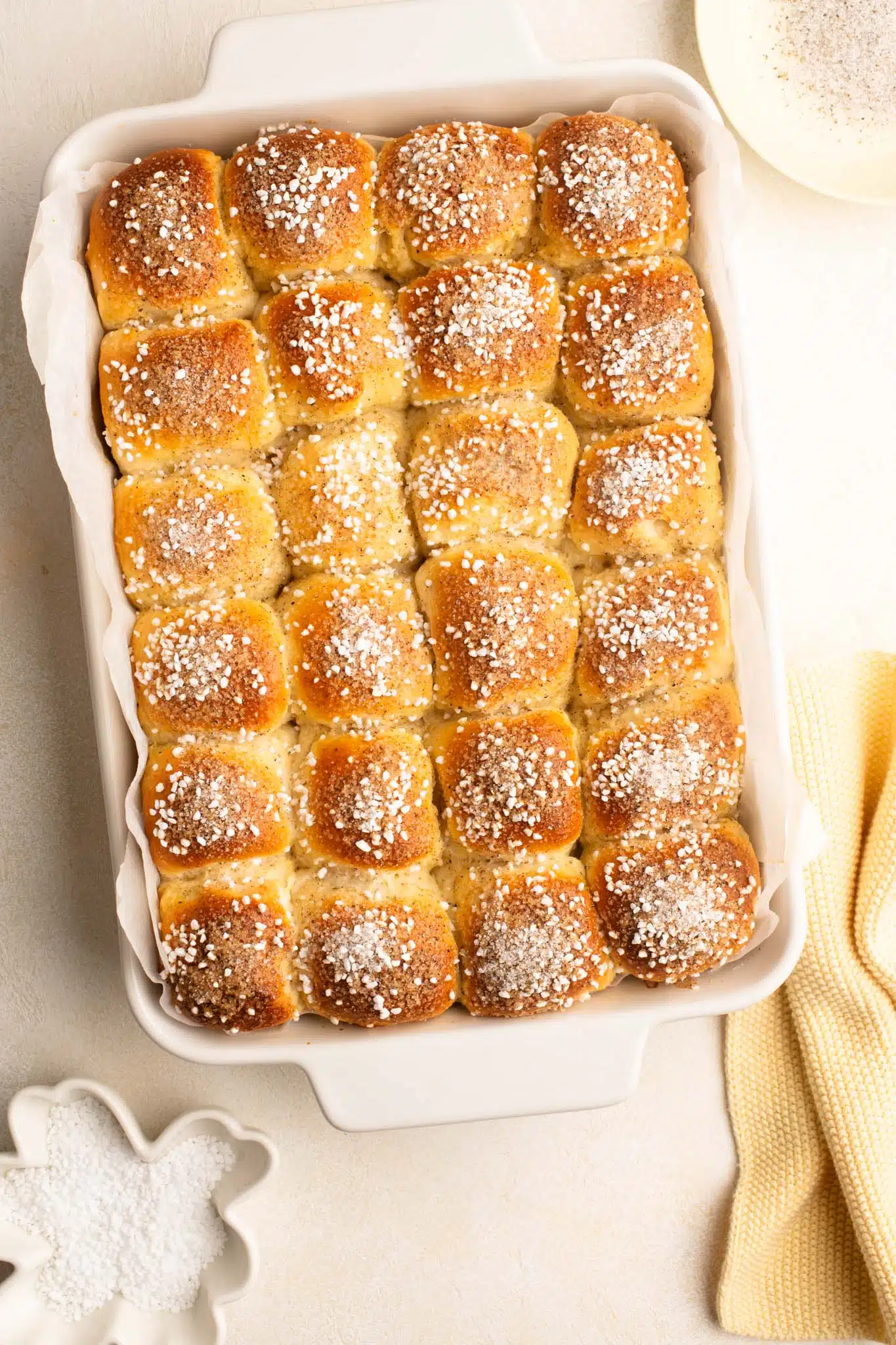 mini cardamom buns sprinkled with pearl sugar in ceramic baking dish