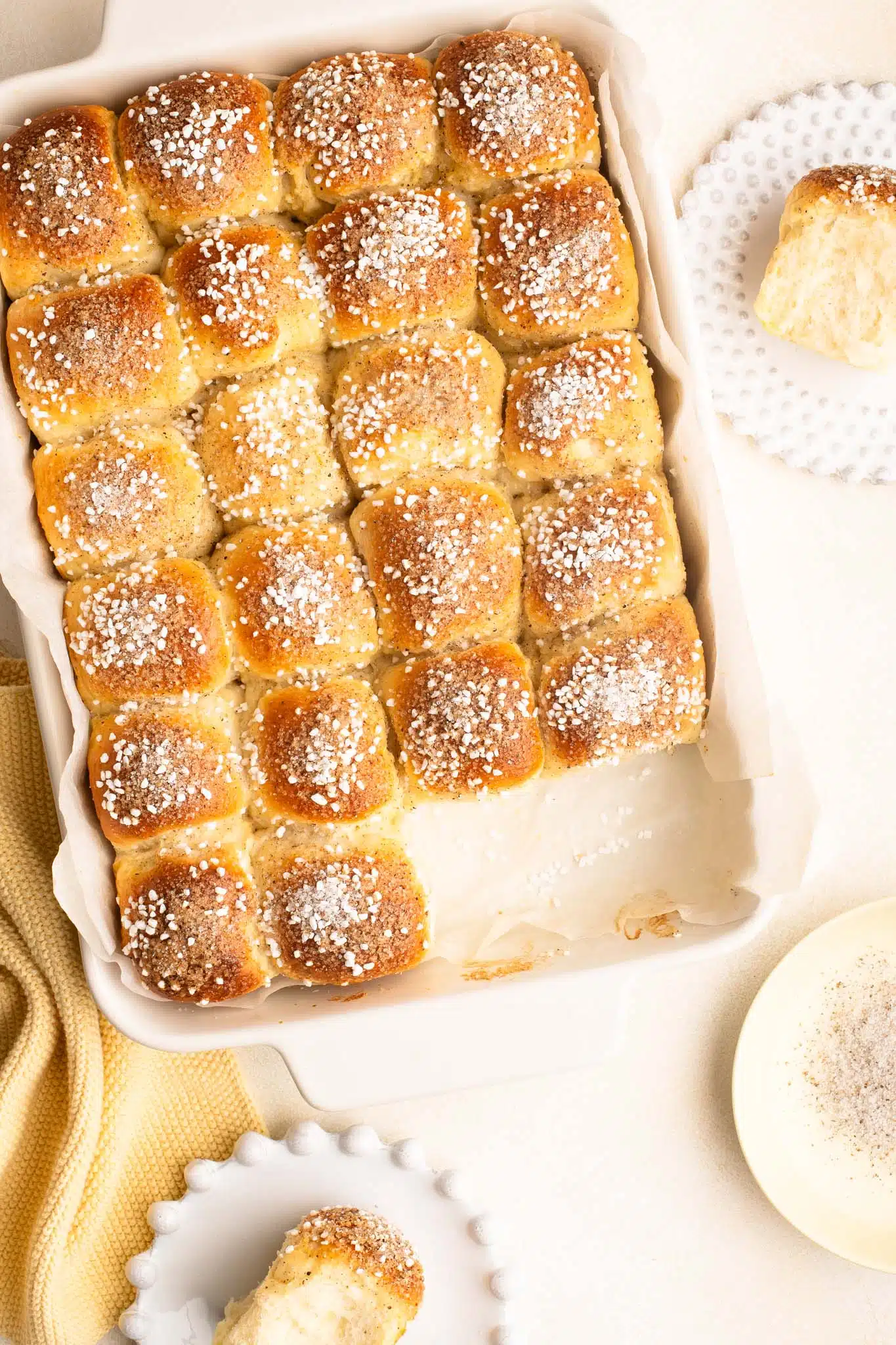 mini cardamom buns sprinkled with pearl sugar in a white baking dish