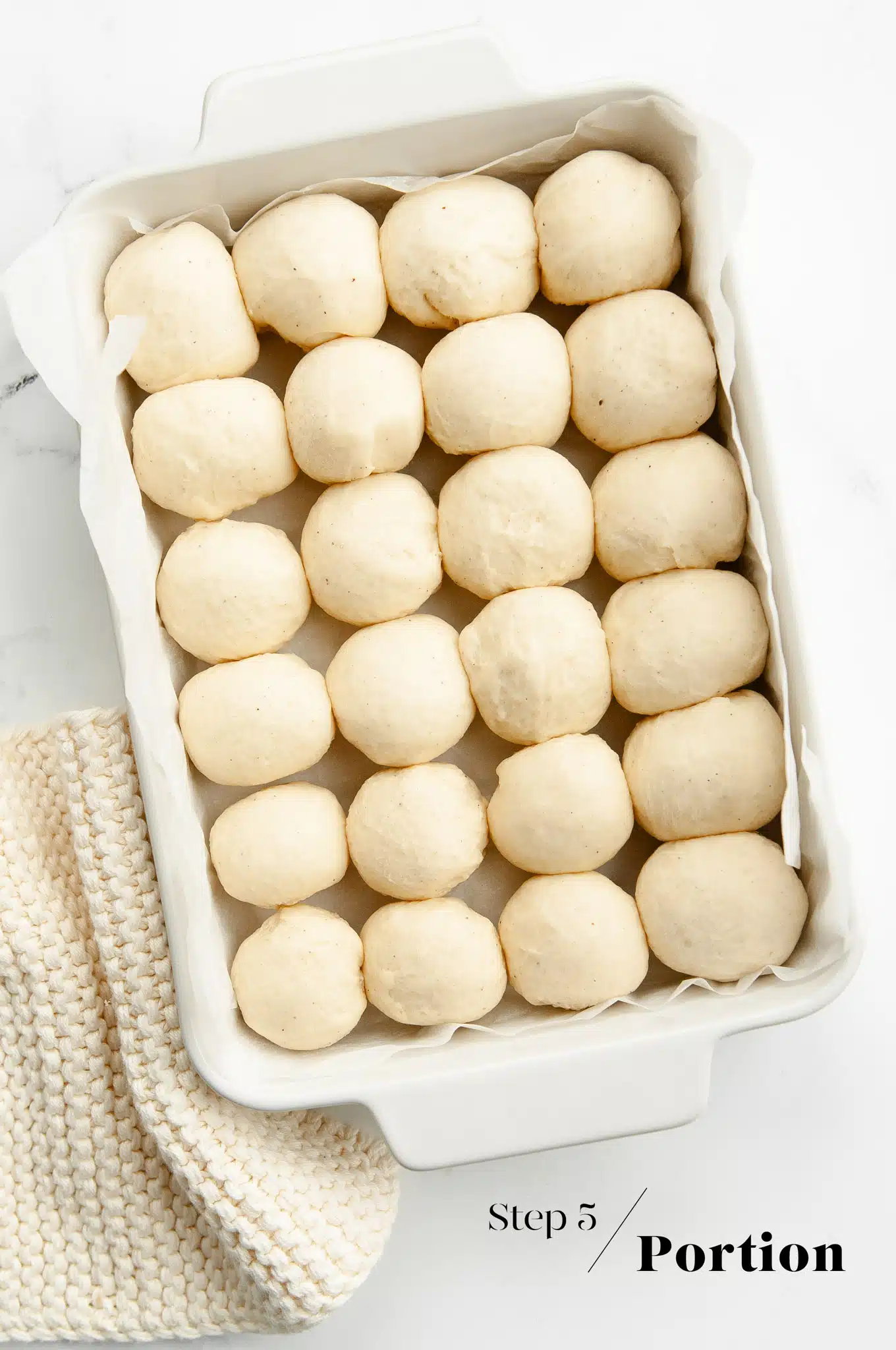mini dough balls in white baking dish before proofing