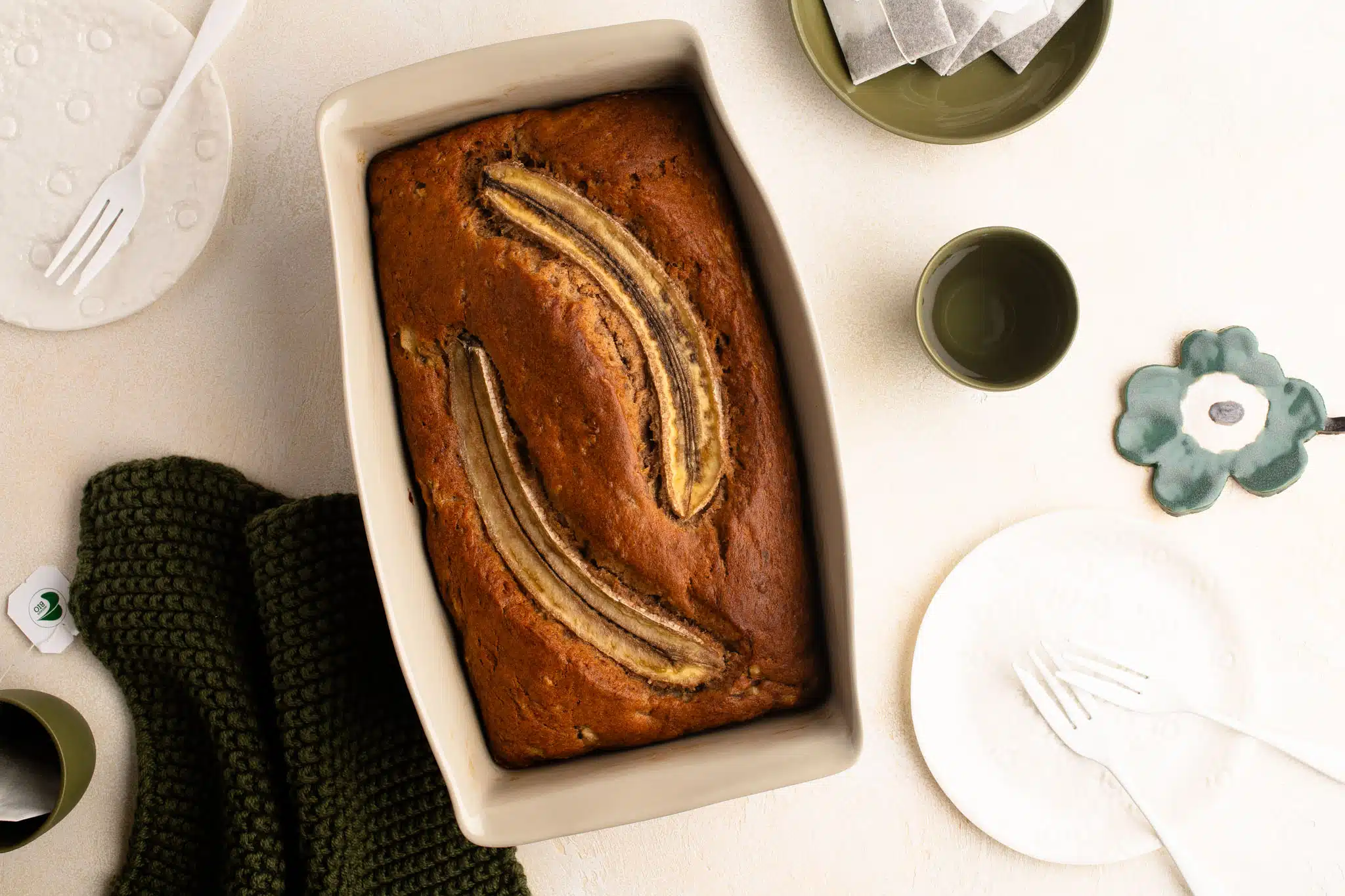 banana bread in load pan with white plates